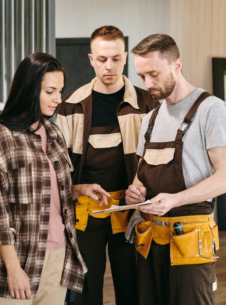 two-plumbers-showing-young-woman-where-to-put-signature.jpg