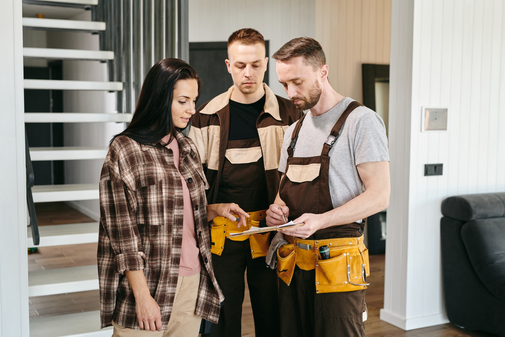 two-plumbers-showing-young-woman-where-to-put-signature.jpg